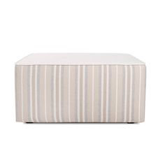 a striped ottoman that is sitting on top of a white tablecloth with grey and beige stripes