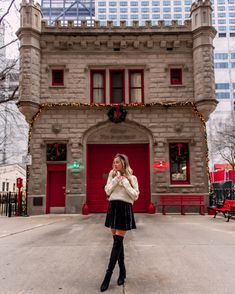 a woman standing in front of a red door