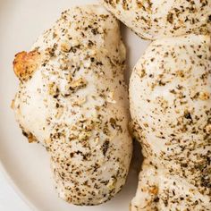 three pieces of chicken on a plate with seasoning sprinkled on it's side