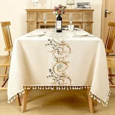 a table with a bottle of wine on it and two wooden chairs around the table