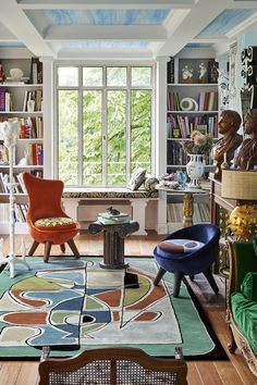 a living room filled with lots of furniture and bookshelves next to a window