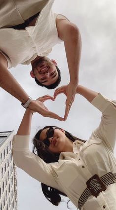 two people making a heart shape with their hands