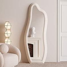 a white chair sitting in front of a mirror on the wall next to a fireplace