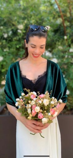 a woman holding a bouquet of flowers in her hands