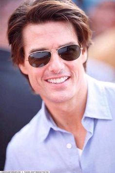 a man wearing sunglasses and smiling for the camera