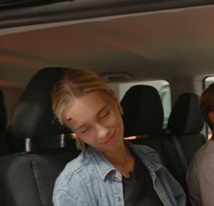 two people sitting in the back seat of a car