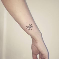 a woman's arm with a small tattoo on it, and a flower in the middle