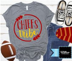 a shirt with the words chiefs tribe on it next to a pair of jeans and sneakers