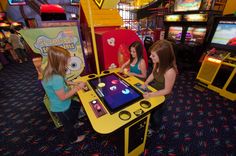 two girls playing an interactive game in a play room with other children's games