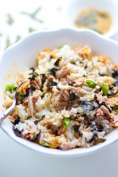 a white bowl filled with rice and meat