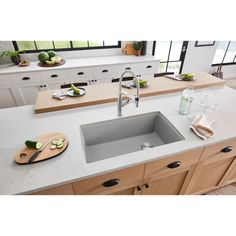 a kitchen sink sitting on top of a counter next to a cutting board and knife