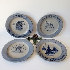 four blue and white christmas plates with santa's sleigh, reindeer, snowman