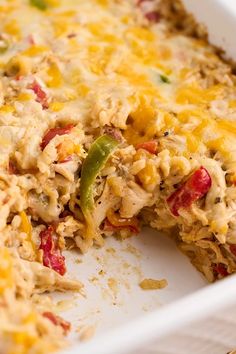 a casserole dish with chicken, peppers and cheese on it's side