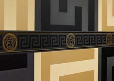 a black and gold wall hanging with lions on it's sides in an art deco style