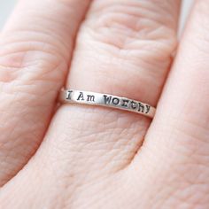 Skinny sterling silver ring that measures 2mm wide stamped with I am Worthy. Ring can come in sizes 4, 5, 6, 7, 8, 9, and 10. *Due to the process of hand stamping in each letter, the ring can stretch to be up to 1/2 size larger. Not sure of your ring size? Head over to this free printable to find your size. https://www.jewelry-secrets.com/Blog/wp-content/uploads/2015/05/Ring-Size-Chart1.pdf All Simpli Stamped jewelry comes ready to gift, packaged in a charming kraft box, tied with a coordinating Inspirational Promise Jewelry, Meaningful Stamped Jewelry For Promise, Meaningful Hypoallergenic Jewelry For Promise, Meaningful Hypoallergenic Promise Jewelry, Hypoallergenic Meaningful Jewelry For Promises, Inspirational Stackable Jewelry As A Gift, Inspirational Stackable Jewelry As Gift, Inspirational Hypoallergenic Jewelry For Anniversary, Inspirational Engraved Jewelry For Anniversary