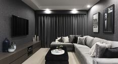 a modern living room with black and white decor on the walls, couches, coffee table and television