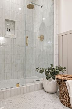 a bathroom with a tub, sink and shower head in the corner next to a basket on the floor