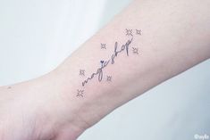 a small heartbeat tattoo on the left inner arm, with stars around it and an arrow in the middle