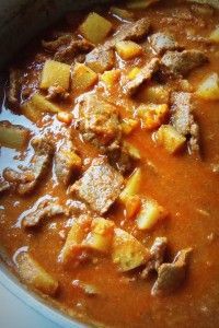 a pot filled with stew and potatoes on top of a stove