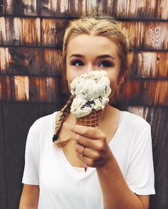 a girl eating an ice cream cone with her hands