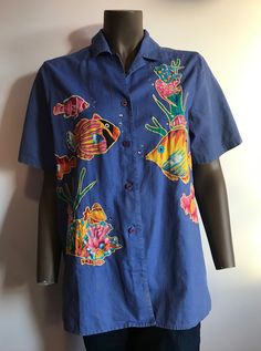 "I'm sorry but you must love tropical fish to wear this shirt. I found it in Hawaii. It's super fun with lots of colorful fish and rhinestone bubbles embroidered on the front and back. It's a button down short sleeve shirt. 55% linen 45% cotton. Size Small. My boyfriend tried it on and he's a medium and it fit. So please use the measurements compared with a similar shirt to determine fit. Label says Quacker Factory (amazing!). It does have some discoloration on front lower right (see photo) and Blue Button-up T-shirt For Summer, Embroidered Short Sleeve Beach Shirt, Embroidered Short Sleeve Shirt For Beach, Embroidered Collared Beach Top, Fun Cotton Short Sleeve Camp Shirt, Cotton Short Sleeve Top With Fish Print, Short Sleeve Cotton Shirt With Fish Print, Cotton Short Sleeve Shirt With Fish Print, Blue Fish Print Top For Summer