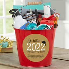 a pink bucket filled with personalized items on top of a table