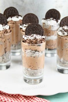 oreo cookies and cream desserts in small glasses on a white plate with a red napkin