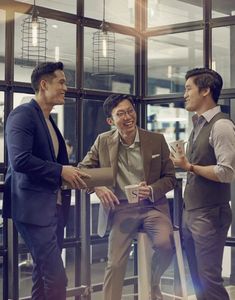 three men in suits talking to each other