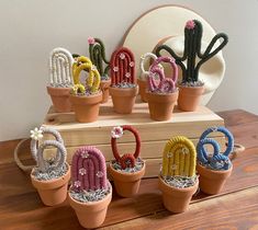 a group of small cactus plants sitting on top of a wooden table next to each other