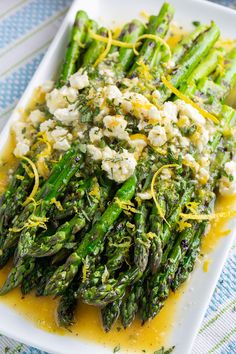 asparagus with feta cheese and mustard on a white plate