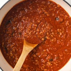 a wooden spoon in a pot filled with chili