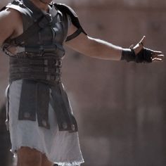 a man dressed in roman armor holding out his hand