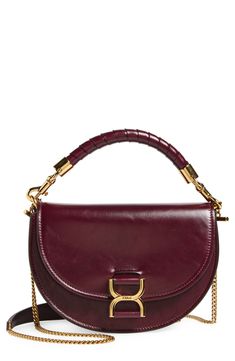 Stirrup-inspired hardware furthers the equestrian aesthetic of this updated version of Chloé's iconic Marcie saddlebag in shiny, crinkled leather. A wrapped top handle and chain shoulder strap—both removable—offer styling options for the chic look. Magnetic-snap flap closure Removable top carry handle; removable chain shoulder strap Interior wall pocket Leather Made in Italy Designer Handbags This brand has B Corp certification, representing business practices with emphasis on social and environ Evening Saddle Bag With Gold-tone Hardware, Equestrian Aesthetic, Chloe Marcie, Stirrups, Interior Wall, Wall Pockets, Emphasis, Handle Bag, The Chic