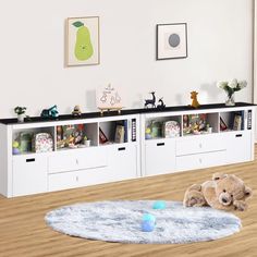 a teddy bear laying on the floor in front of a bookcase