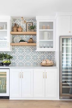 a kitchen with white cabinets and glass doors