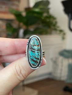 "This piece of turquoise has so much character with blues, browns, and whites running through it.  I gave her a hand stamped sterling wire accent and set her on a triple wire band.  This ring has been oxidized to bring out the details and give her a rustic feel. Measurements:  1.3\" x .6\" Ring Size:  8 Turquoise is known as the master healing stone.  Attributed to the power of connecting mind, body, and soul, it is also a symbol of superior energies and spiritual openness When you purchase from Crimson Buffalo you are getting a one-of-a-kind hand- crafted piece of jewelry.  We do not use molds so no two pieces will ever be identical; each will have its own character and markings making them unique and adding to the beauty of a handmade piece of jewelry.  We are so happy that you stopped t Artisan Turquoise Ring With Patina, Western Rings, Silver Turquoise Ring, Petite Ring, Zuni Jewelry, Sterling Silver Rings Turquoise, Southwest Jewelry, Turquoise Ring Silver, Mind Body And Soul