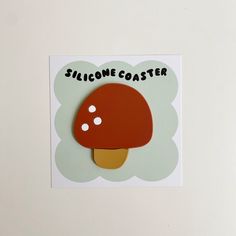 a sticker with a mushroom on it that says, silcone coaster