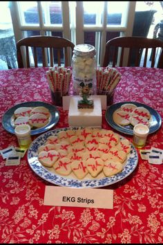 a table topped with lots of cookies on top of a blue and white plate covered in icing