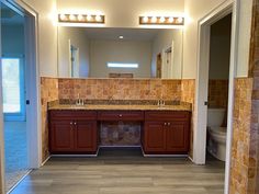 a bathroom with tile floors and brown cabinets