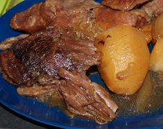 a blue plate topped with meat and potatoes