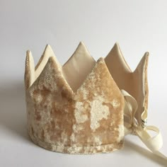 the crown is made out of velvet and has a satin ribbon around the edge that matches the fabric