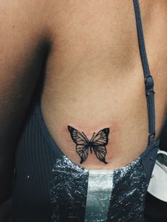 a woman with a butterfly tattoo on her stomach