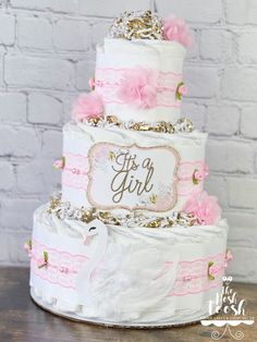 a three tiered cake with pink and gold decorations