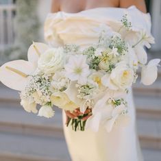 a bridal holding a bouquet of white flowers