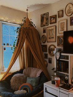 a living room filled with lots of furniture and pictures on the wall next to a window