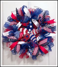 a patriotic wreath with red, white and blue ribbons