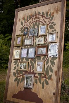 a family tree with pictures on it in front of some trees and grass, surrounded by framed photos