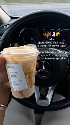 a cup of coffee sitting on the dashboard of a car, with information about it