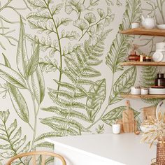 a kitchen with green leaves on the wall and shelves above it, next to a white counter