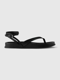 Smooth vegan leather sandals.  Throng strap at top.  Wrapped ankle straps with buckle closure.  Platform sole.  For more fit and sizing info, check out our Size Guide. Black Strappy Platform Sandals, Casual Black Platform Lace-up Sandals, Black Platform Lace-up Sandals For Summer, Edgy Black Platform Sandals, Platform T-strap Sandals With Ankle Strap For Beach, Strappy Platform Sandals, Ankle Straps, Summer Shoes, Platform Sandals